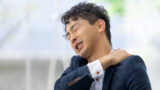 肩こりに悩む男性ビジネスマン｜逗子カイロプラクティック アナタのチカラ